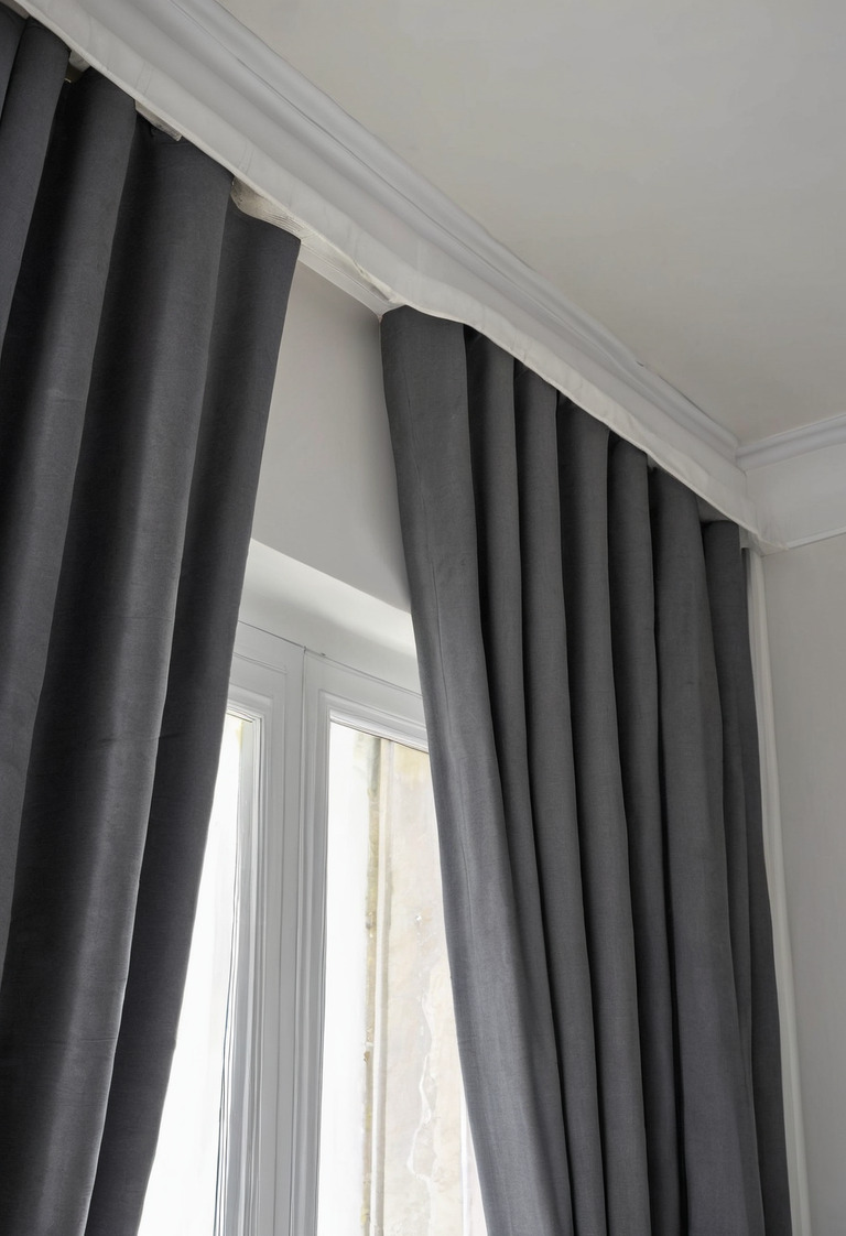 Close view of a blackout curtain returning into a wall recess beside a bedroom window