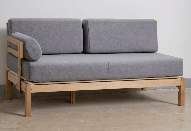 Upholstered sofa construction sample showing timber frame, webbing, foam, and cover layers