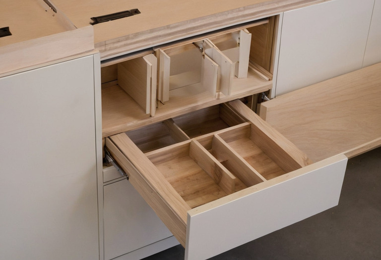 Concealed cabinet hinge and under-mounted drawer runner installed in a workshop mock-up