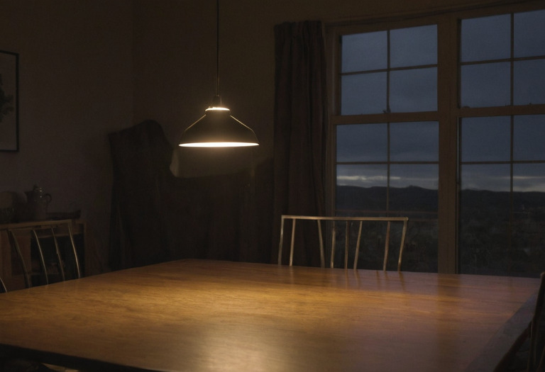 Pendant shade aligned with a cardboard eye-line guide across a dining table
