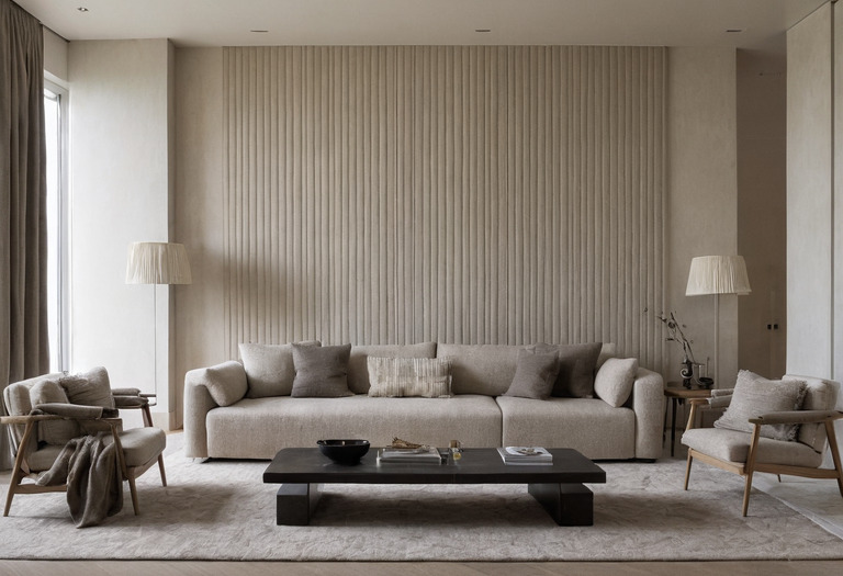 Living room combining matte plaster, ribbed oak, woven upholstery and honed stone